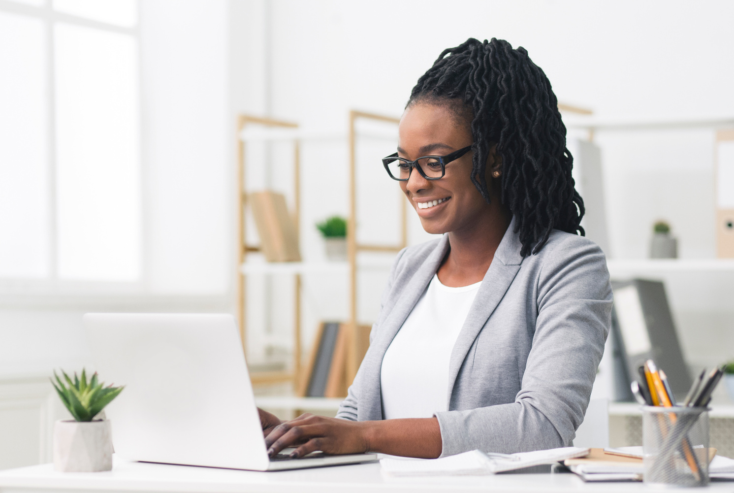 Black Female Entrepreneur Using Laptop In Modern Office